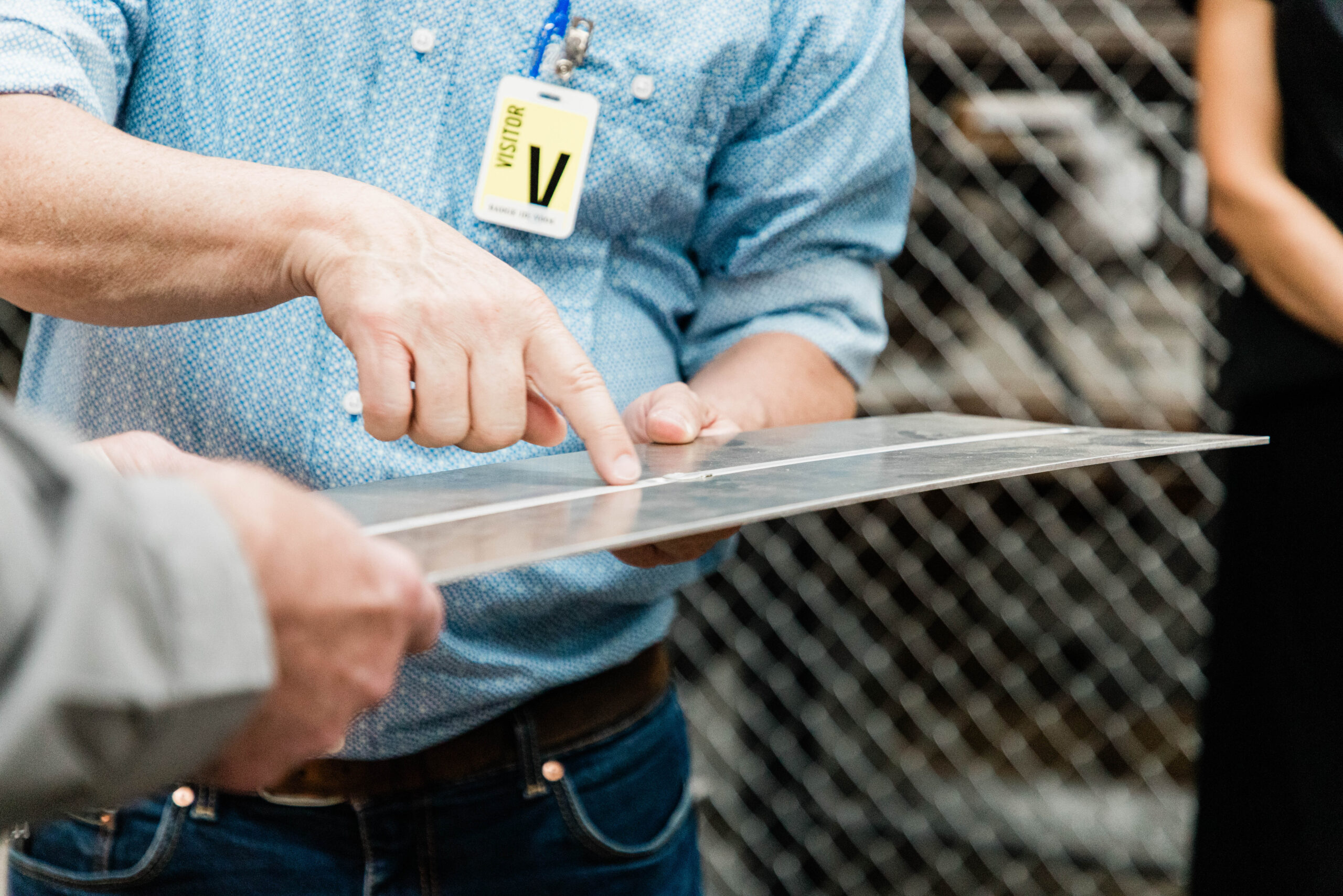 VRC Metal Systems representative points to a metal component during a facility tour in Box Elder, South Dakota.